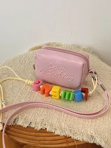 Pink mini square crossbody bag with colorful alphabet bead strap and embossed text.
