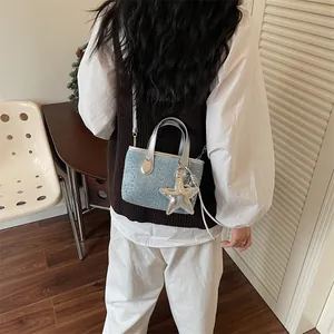 Detailed view of a light blue studded mini handbag with a decorative silver star charm