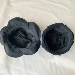 Close-up view showing the internal lining and petal-shaped brim of a black bucket hat