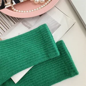 Macro view of green ribbed knitted fingerless gloves with soft texture.