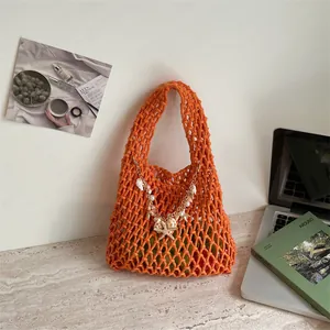 Chique oranje geweven handtas met schelphanger in een modern thuiskantoor