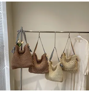 Groupe de sacs fourre-tout en paille tressée de différentes couleurs sur un support.