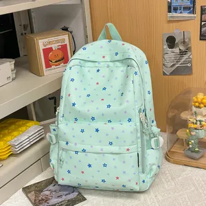 Mint green backpack with colorful star pattern shown in a student lifestyle desk setting