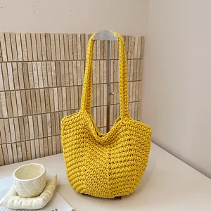 Detailed close-up of a vibrant yellow handmade woven shoulder bag on a display stand.