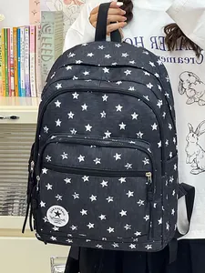 Detailed view of a black star-patterned student backpack held in a lifestyle scene