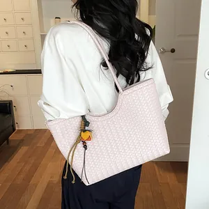 Detalle del bolso tote tejido rosa minimalista mostrado como bolso de hombro grande