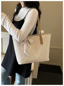 Large beige fashion tote bag with geometric embossed pattern and silk scarf detail.