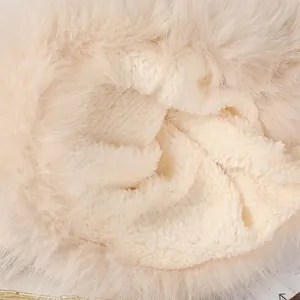 Close-up detail of the soft sherpa lining and plush fur trim of a winter hat.