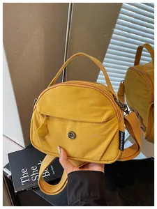 Primer plano de un elegante bolso bandolera de lona amarilla con detalles de cremallera