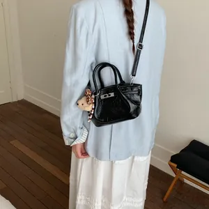 Primo piano dettagliato di una piccola borsa nera alla moda con un ciondolo a forma di orso