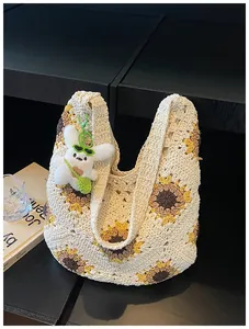 Vista dettagliata della borsa tote all'uncinetto con girasoli e ciondolo coniglio peluche