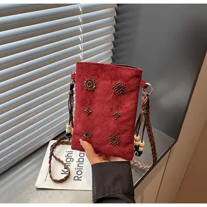 Close-up detail of a vintage red velvet crossbody bag featuring exquisite beadwork
