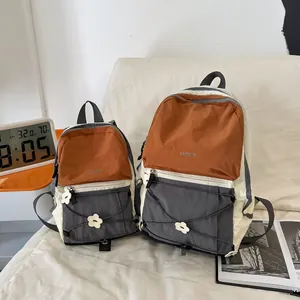 Detailansicht großer und kleiner farbenfroher Wanderrucksäcke in Creme, Orange und Grau