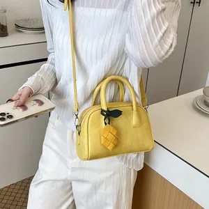 Detailed view of stylish yellow pillow bag worn by a model in a minimal setting