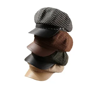 Stacked striped newsboy hats with leather brims in four different colors.