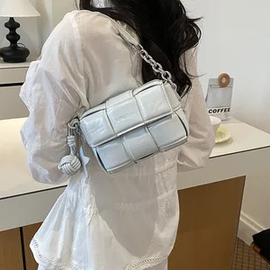 Detailed view of a light grey minimalist woven leather shoulder bag with a silver chain strap