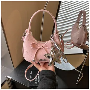 Close-up of pink hobo bag featuring bow detail, star patterns and a silver star charm