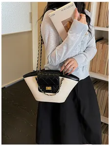 Mannequin tenant un sac fourre-tout en paille tissée avec rabat en cuir