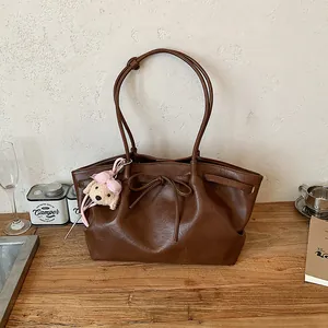 Vintage bruine leren tote tas voor dames met een schattige puppy hanger en strikje.