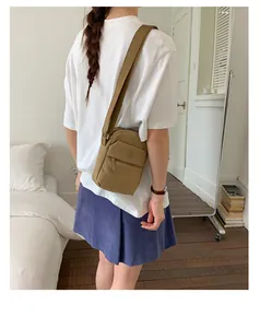 Back view of model wearing a khaki casual square crossbody bag in a lifestyle setting