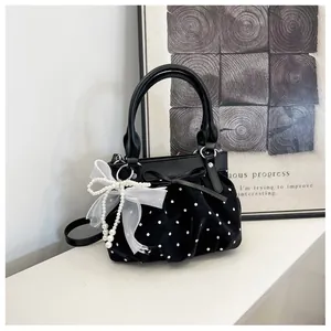 Chic black polka dot pleated bucket bag detail with elegant bow and pearl ribbon charm