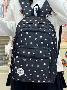 Detailed shot of a stylish black backpack with white star patterns and a star pendant.