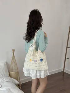 Detail einer handgefertigten Häkel-Tragetasche mit bunten gestrickten Blumendekoren