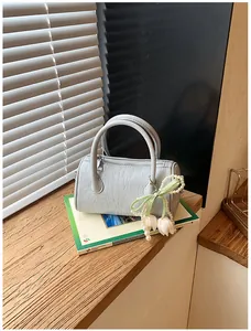 Detail view of light blue pillow bag with pearl tulip charm on wooden window sill