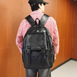 Vue arrière d'un homme portant un grand sac à dos de voyage vintage en cuir noir à boucles