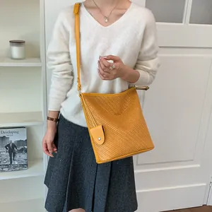 Elegante gele geweven emmer tas met verstelbare riem voor een chique casual mode-look.