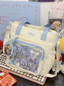 Close-up detailed view of white tote bag clear front pocket with anime badges display