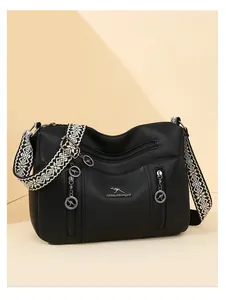 Black pebbled leather crossbody bag with ethnic patterned strap and kangaroo charms