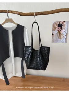 Detailed view of a black woven pattern tote bag in a versatile vintage style