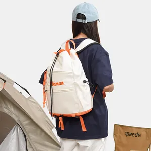 Détail du sac à dos à cordon crème et orange porté lors d'un camping en plein air