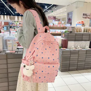 Cute pink backpack with blue star patterns and white plush bear charm detail.