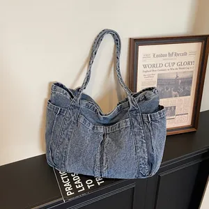 Grand sac cabas en jean bleu vintage avec poches latérales pour les déplacements.