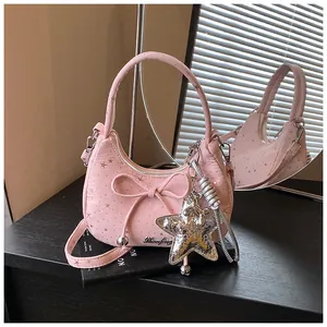Detailed view of pink sweet bow hobo bag with star patterns and large silver pendant