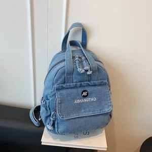 Detailansicht eines hellblauen Denim-Multifunktionsrucksacks für Damen.