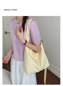 Close-up of a stylish large capacity canvas tote bag with sequin star patterns on a model
