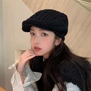 Stylish black knitted newsboy cap for women in retro winter wool beret fashion style.