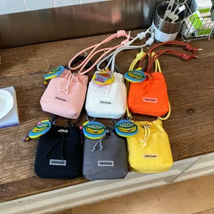 Detail view of summer mesh mini bucket bags in six vibrant colors on wooden surface