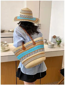 Lifestyle-Ansicht einer großen gewebten Stroh-Strandtasche mit passendem Sonnenhut.