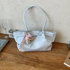 Detailopname lichtblauwe schoudertas met strik en schattige pluche hanger