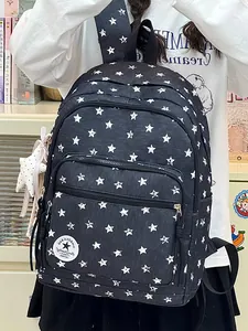 Detailed view of black backpack with white star patterns and plush star keychain.