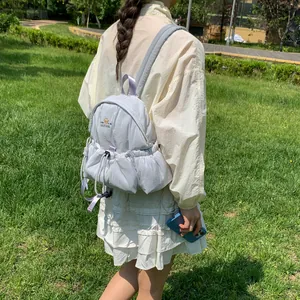 Vista trasera de mujer con mochila blanca minimalista con cordón ajustable en el parque