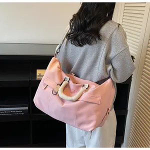 Vue détaillée d'un sac de voyage rose élégant avec grande capacité et bandoulière