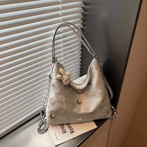 Silver large capacity multi-functional backpack with butterfly design and plush charm detail.