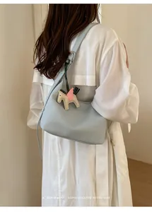 Detail view of the elegant light blue shoulder hobo bag featuring a cute flying horse charm.