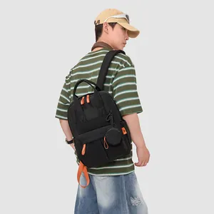 Model trägt einen großen, wasserdichten Outdoor-Rucksack in Schwarz mit orangefarbenen Akzenten