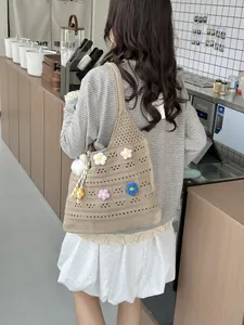 Model trägt eine handgehäkelte Häkel-Einkaufstasche mit bunten Blumendetails
